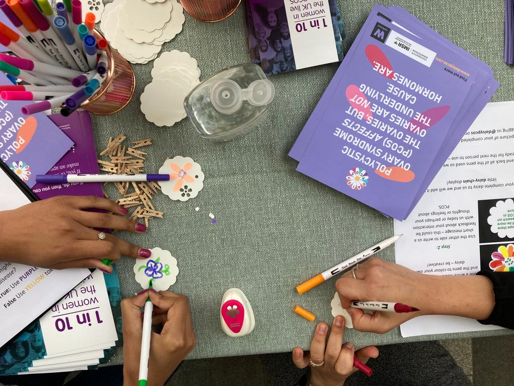 Image shows people drawing pictures of daisy flowers